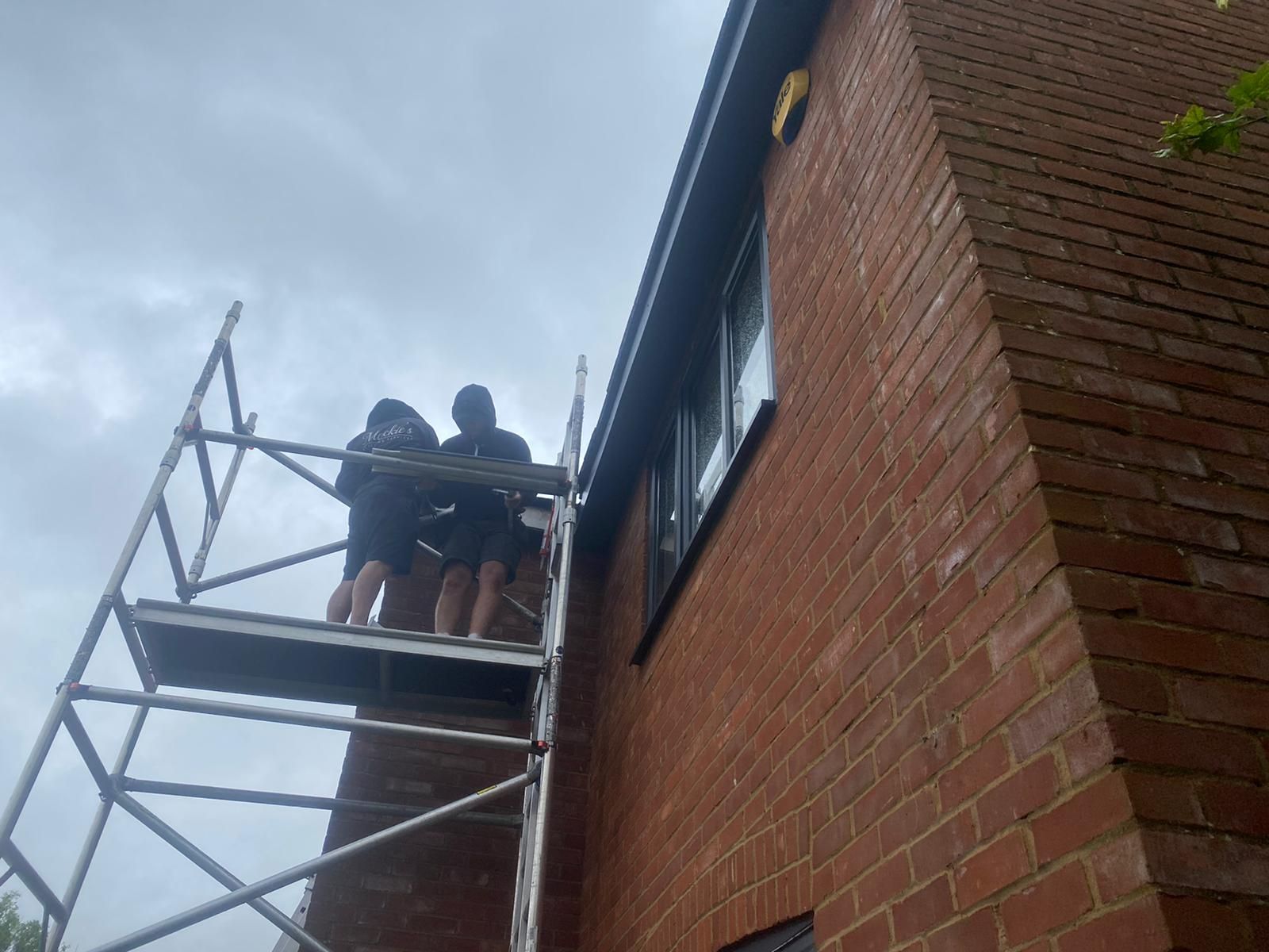 Two cleaners working together on a scaffold