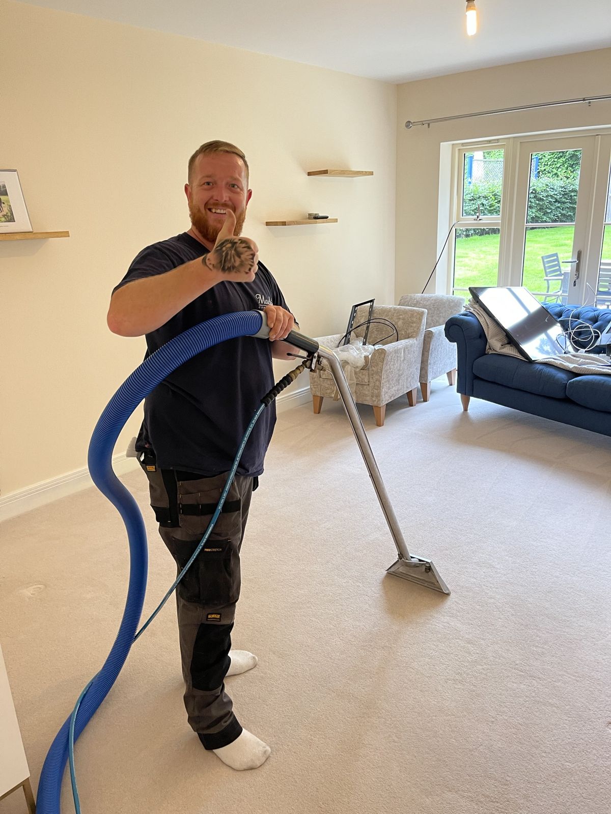 A carpet cleaner giving a thumbs up in a freshly cleaned living room