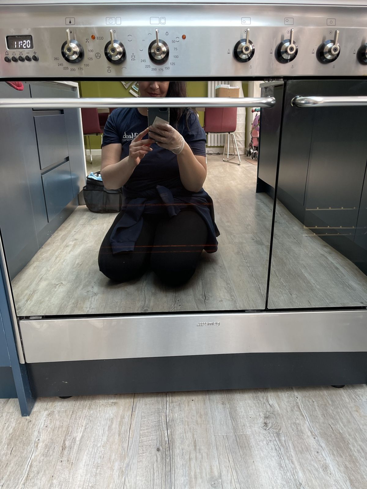A selfie reflected in a freshly cleaned oven door
